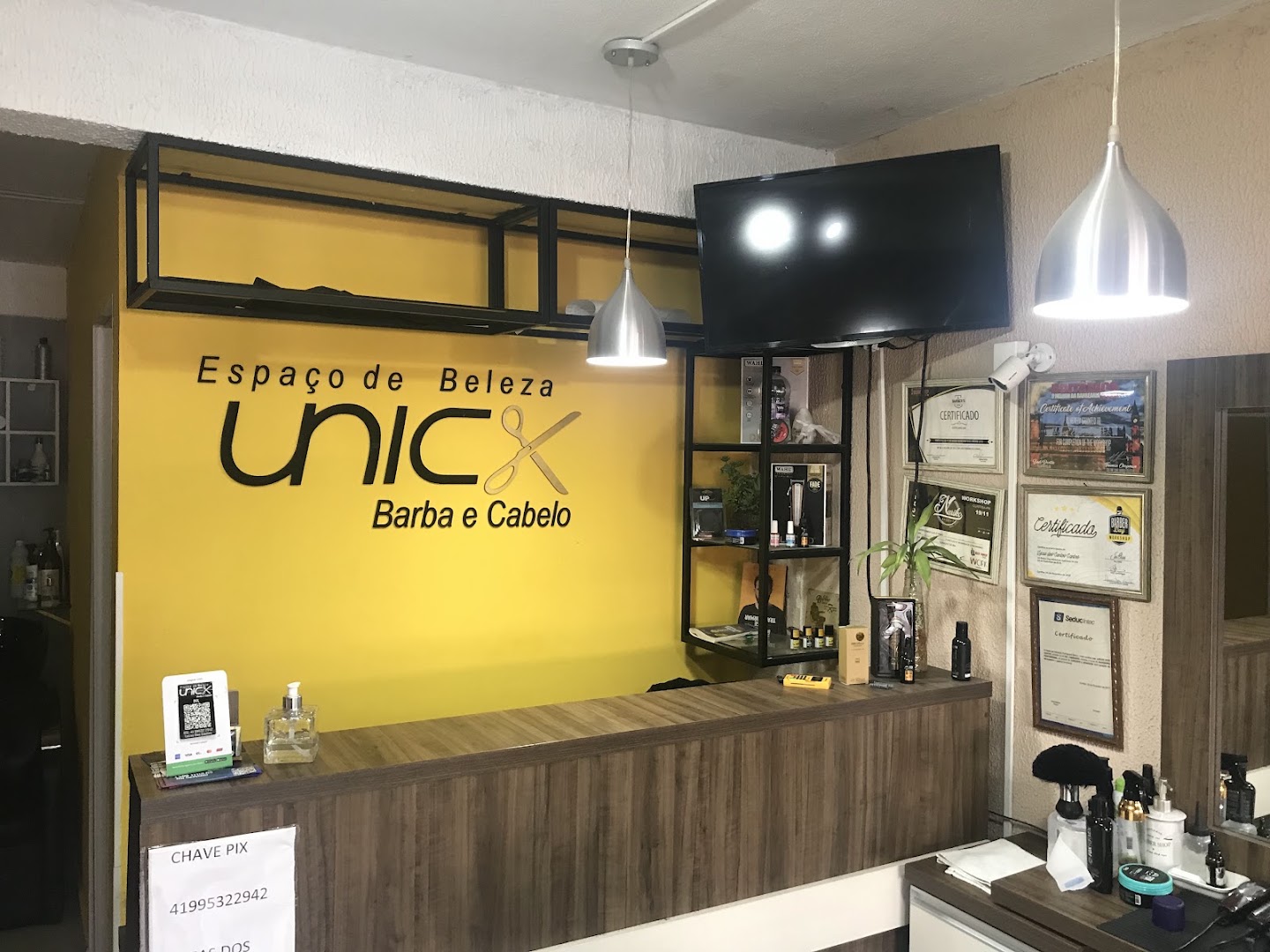 Recepção do Espaço de Beleza Unick, com certificados dos profissionais na parede